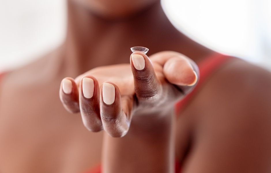 Close up of hand holding a contact lens.